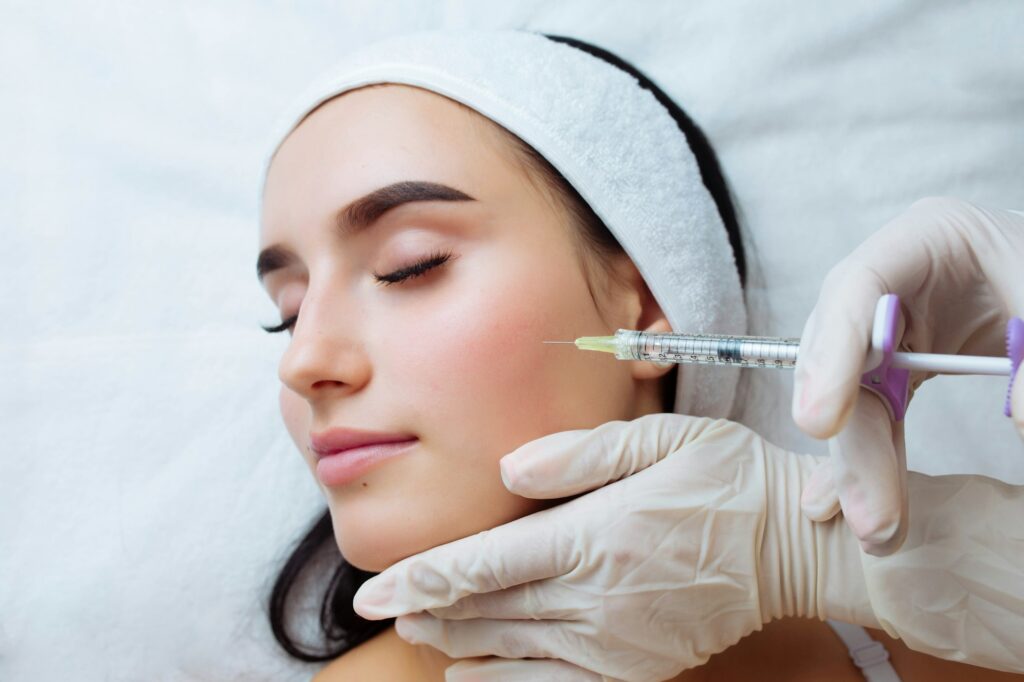 Smile lifting and lip augmentation. Beautician doctor hands doing beauty procedure to female face