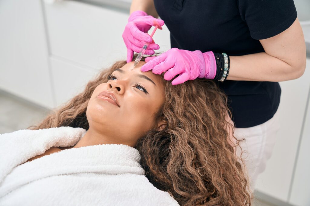 Young woman receives botulinum toxin injections in a cosmetology clinic